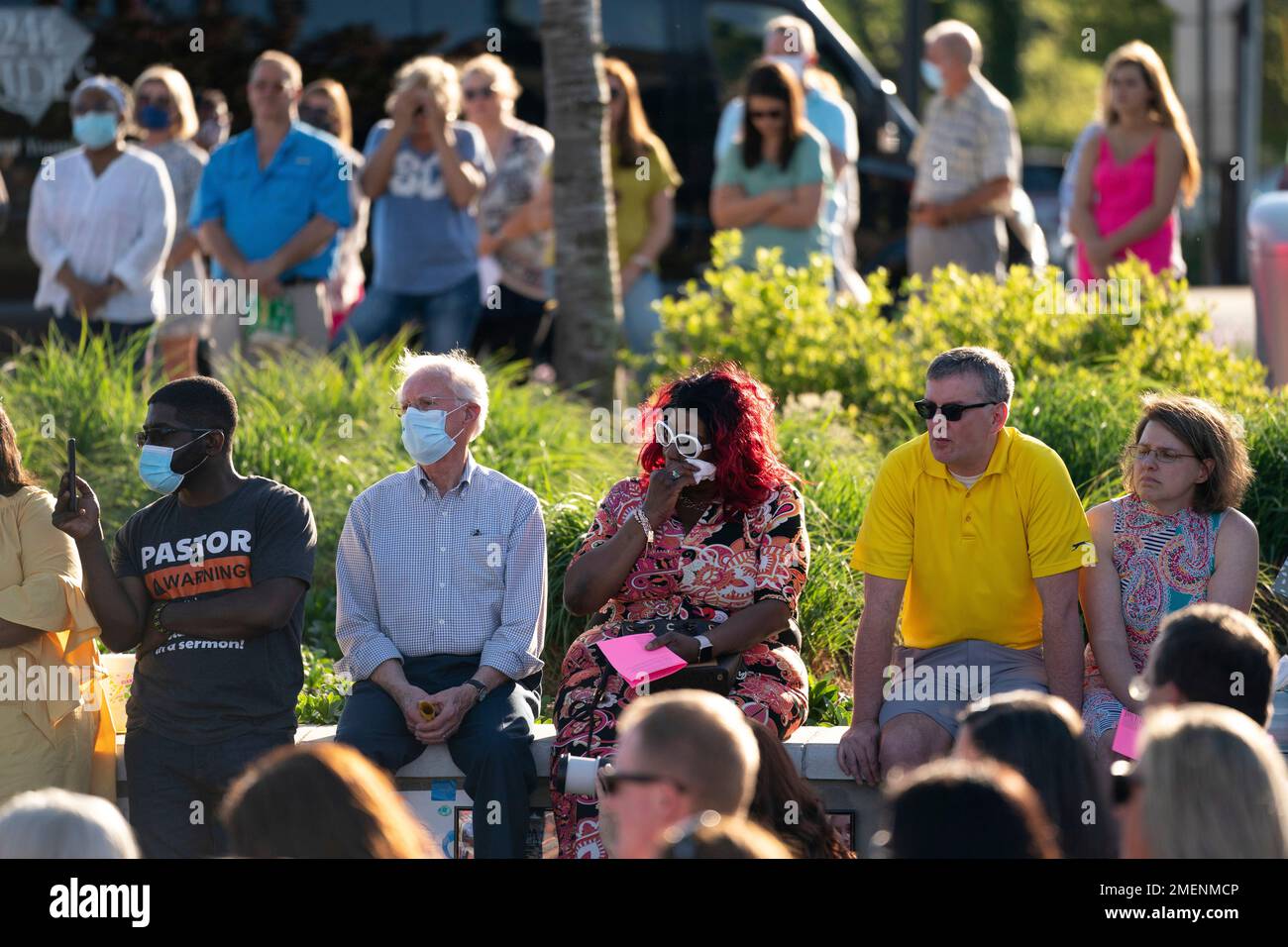 People listen during a memorial service and prayer vigil for the