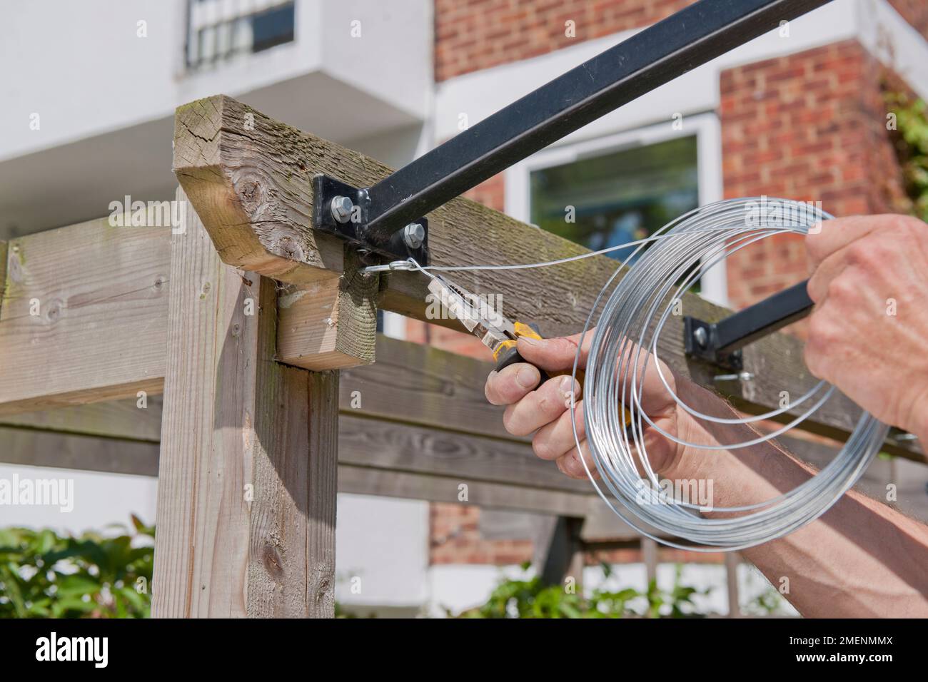 Making a DIY patio canopy securing wire through a vine eye on a