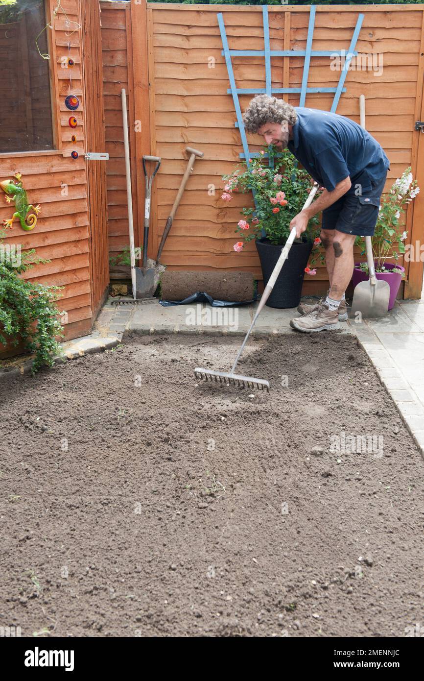 Raking soil in preparation for laying turf Stock Photo Alamy