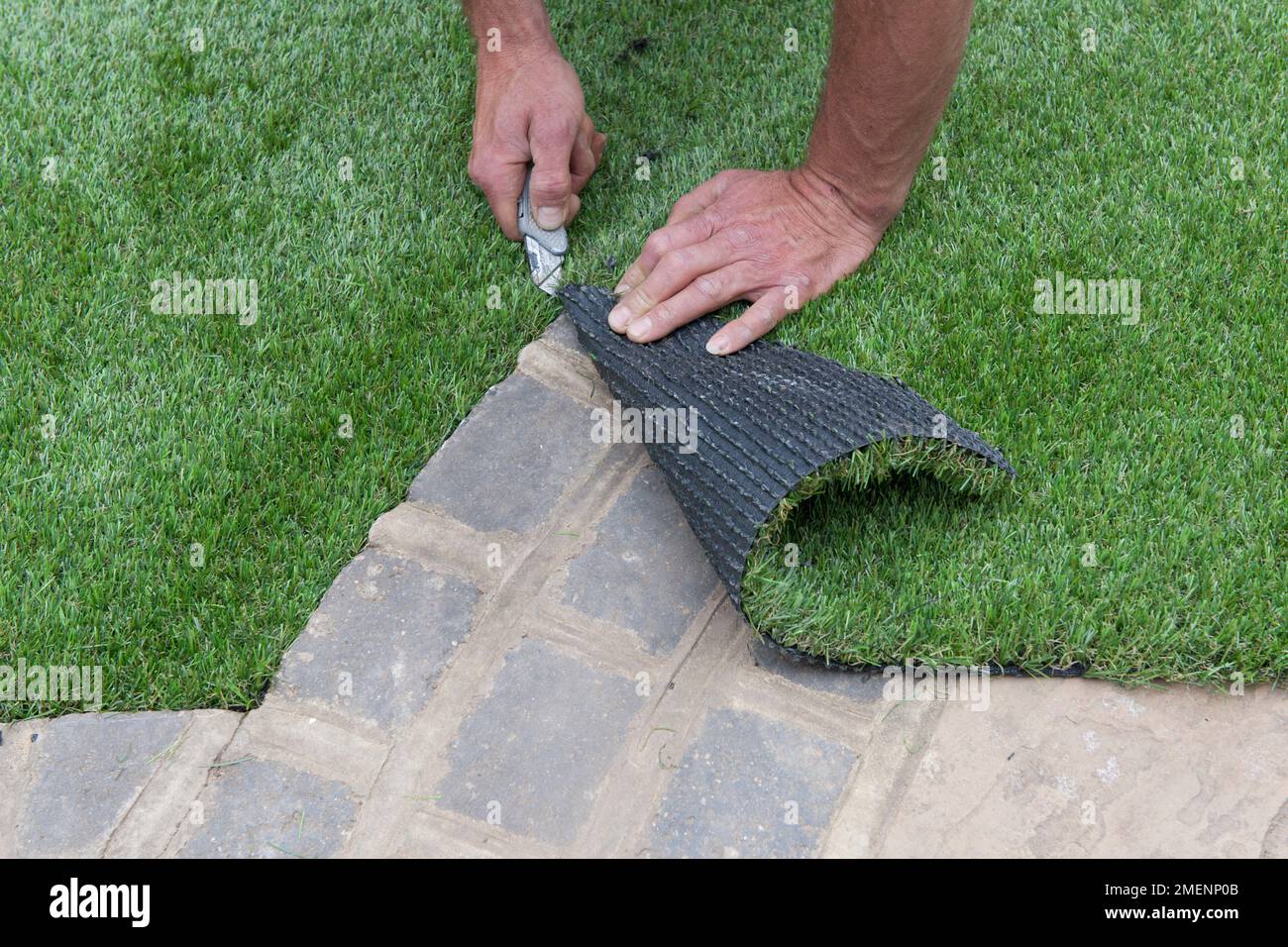 Trimming artificial turf to size using a stanley knife Stock Photo