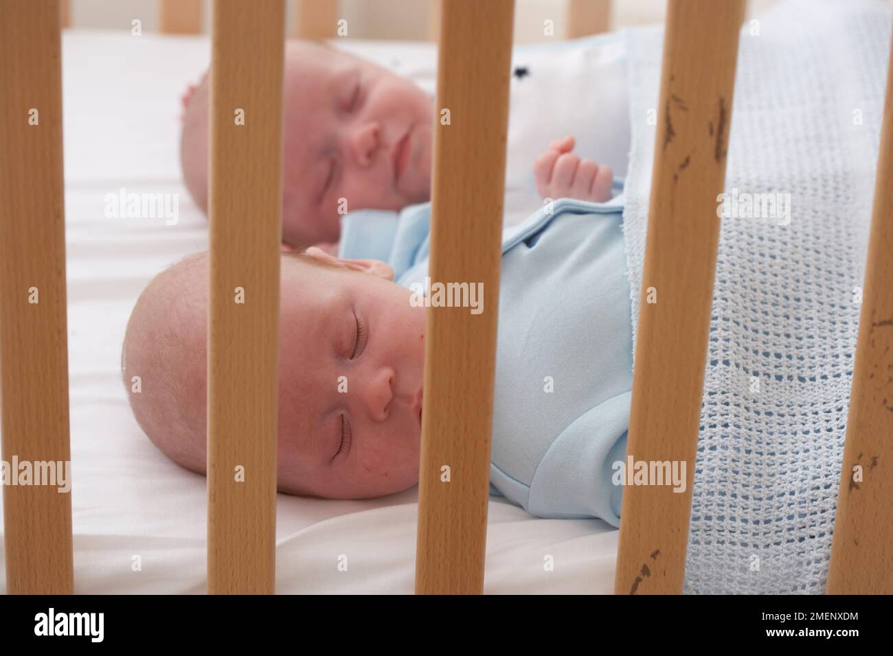 Twin baby boy and girl asleep in cot together, closeup, 5 months Stock