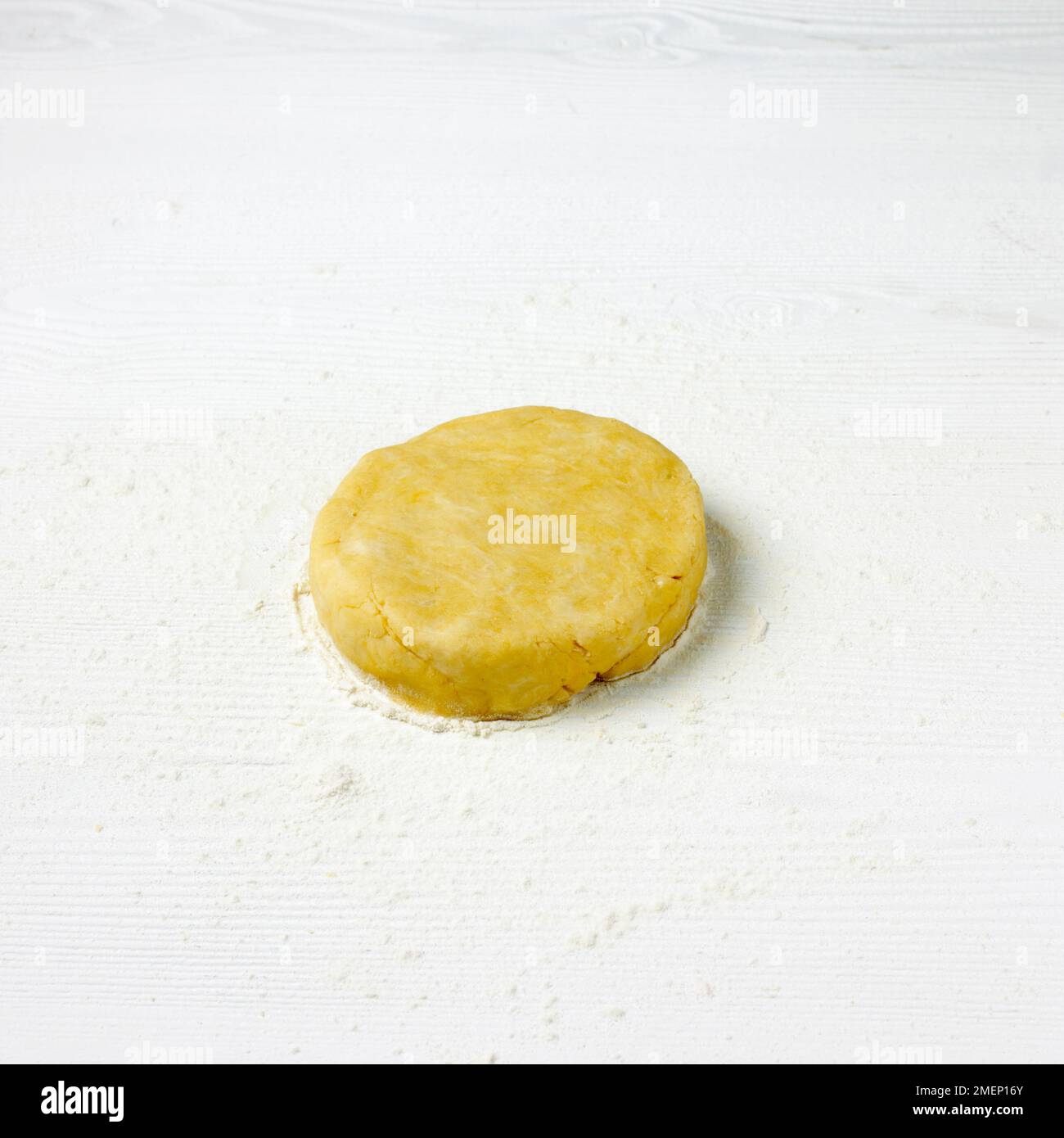 Small disc of shortcrust pastry on floured worktop, close-up Stock Photo