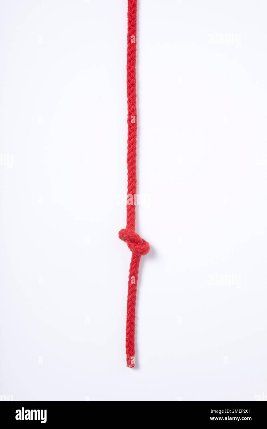 Overhand Knot, simplest of knots tied in red rope Stock Photo