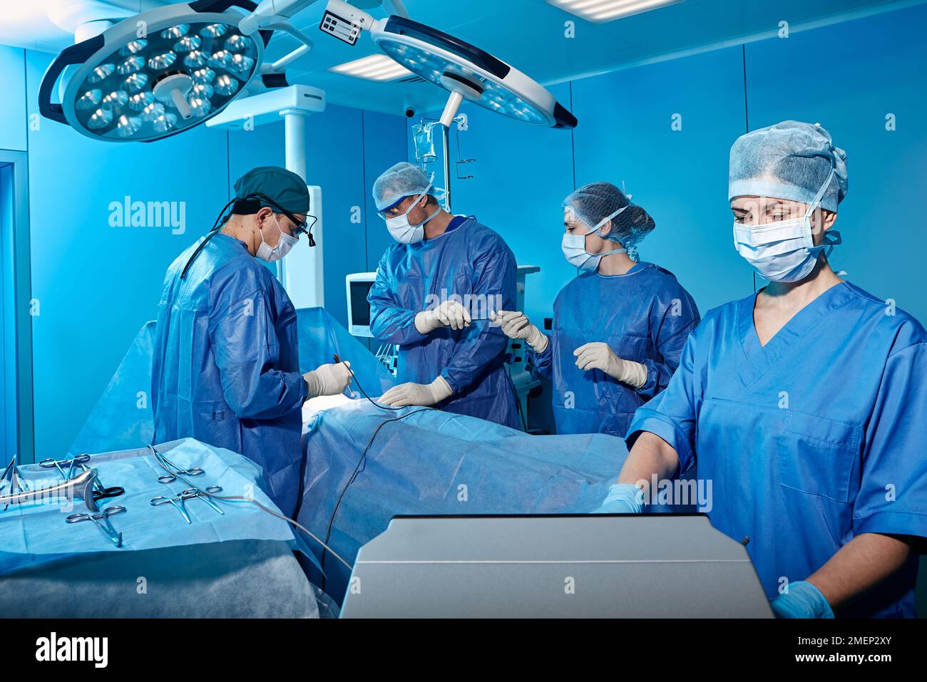 hospital operating theatre with medical team wearing personal protective equipment while surgical operation. Teamwork in surgical department Stock Photo