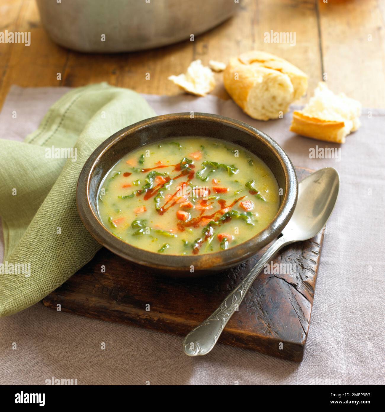 Caldo verde, Portuguese soup in bowl on rustic chopping board Stock Photo