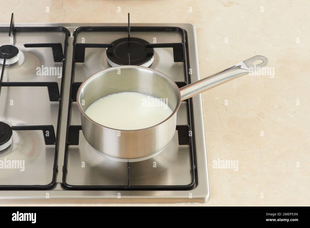 Milk heated in stainless steel saucepan Stock Photo Alamy
