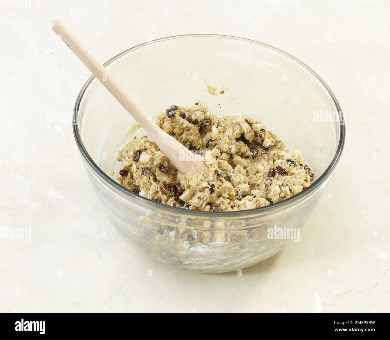 Making Hazelnut and Raisin Oat Cookies, combining the ingredients to form a dough Stock Photo