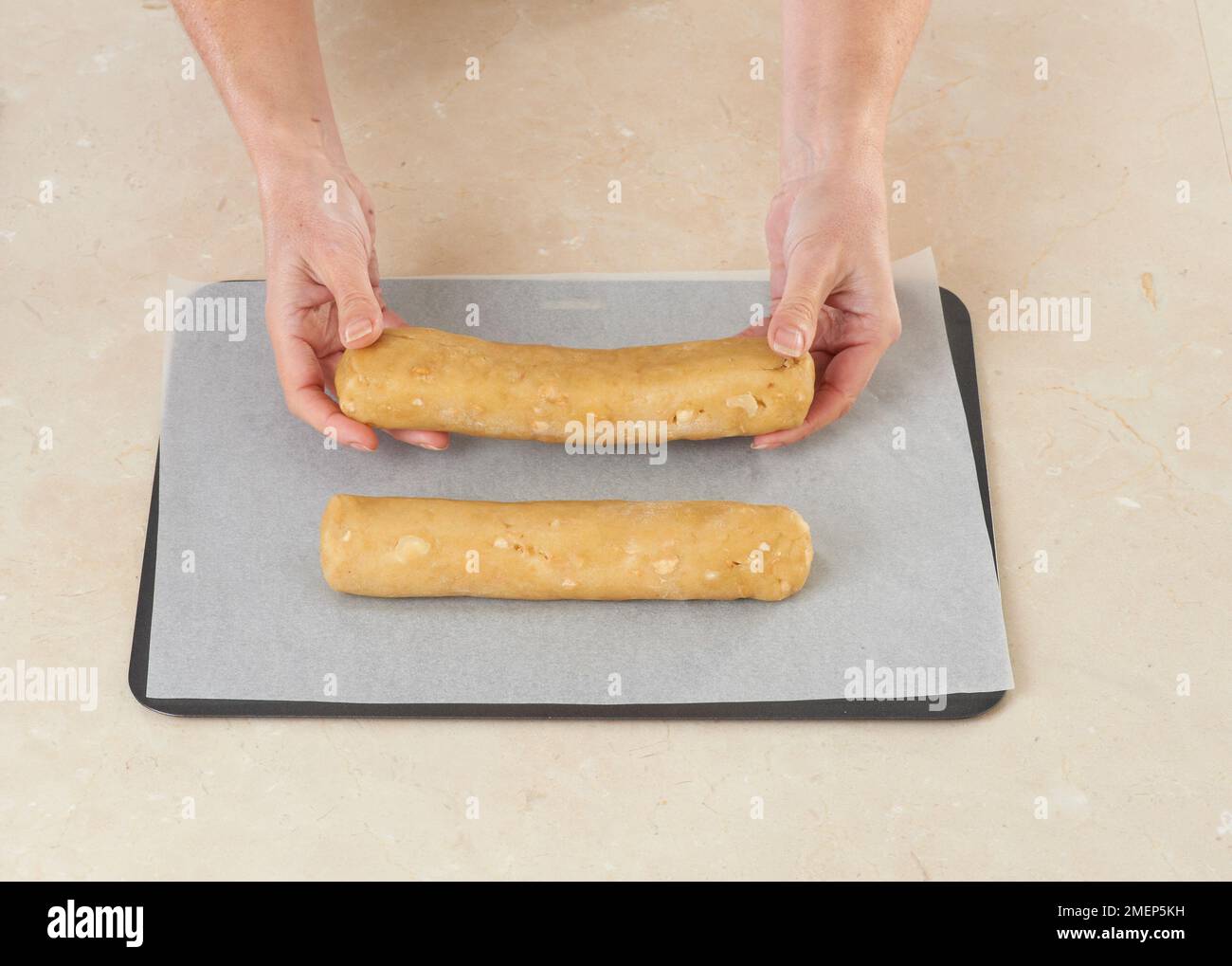 Holding Biscotti shapes on baking tray Stock Photo