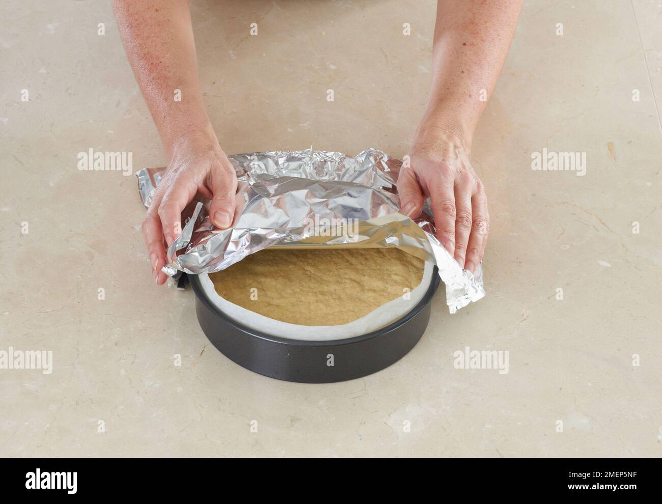 Making Shortbread, covering with foil to protect from browning Stock Photo