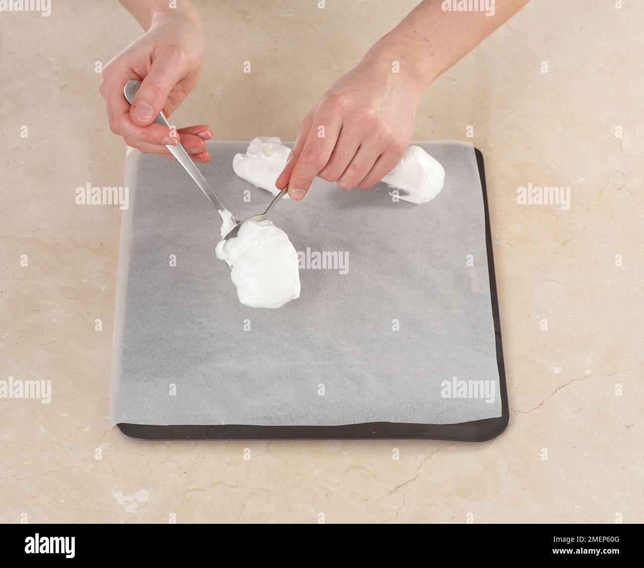 Spooning meringue mixture on baking sheet Stock Photo Alamy