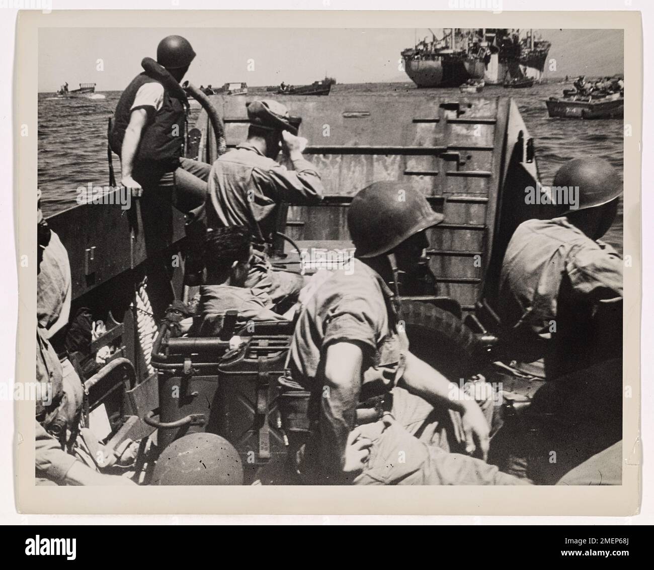 The Invaders Go In At Saipan. Coast Guardsmen operate a landing barge ...