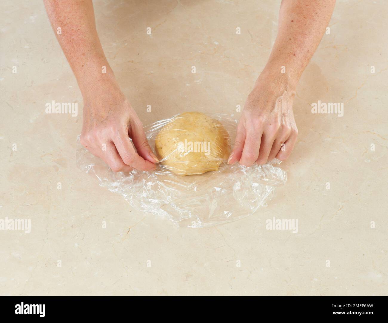 Wrapping pastry dough ball in cling film Stock Photo - Alamy