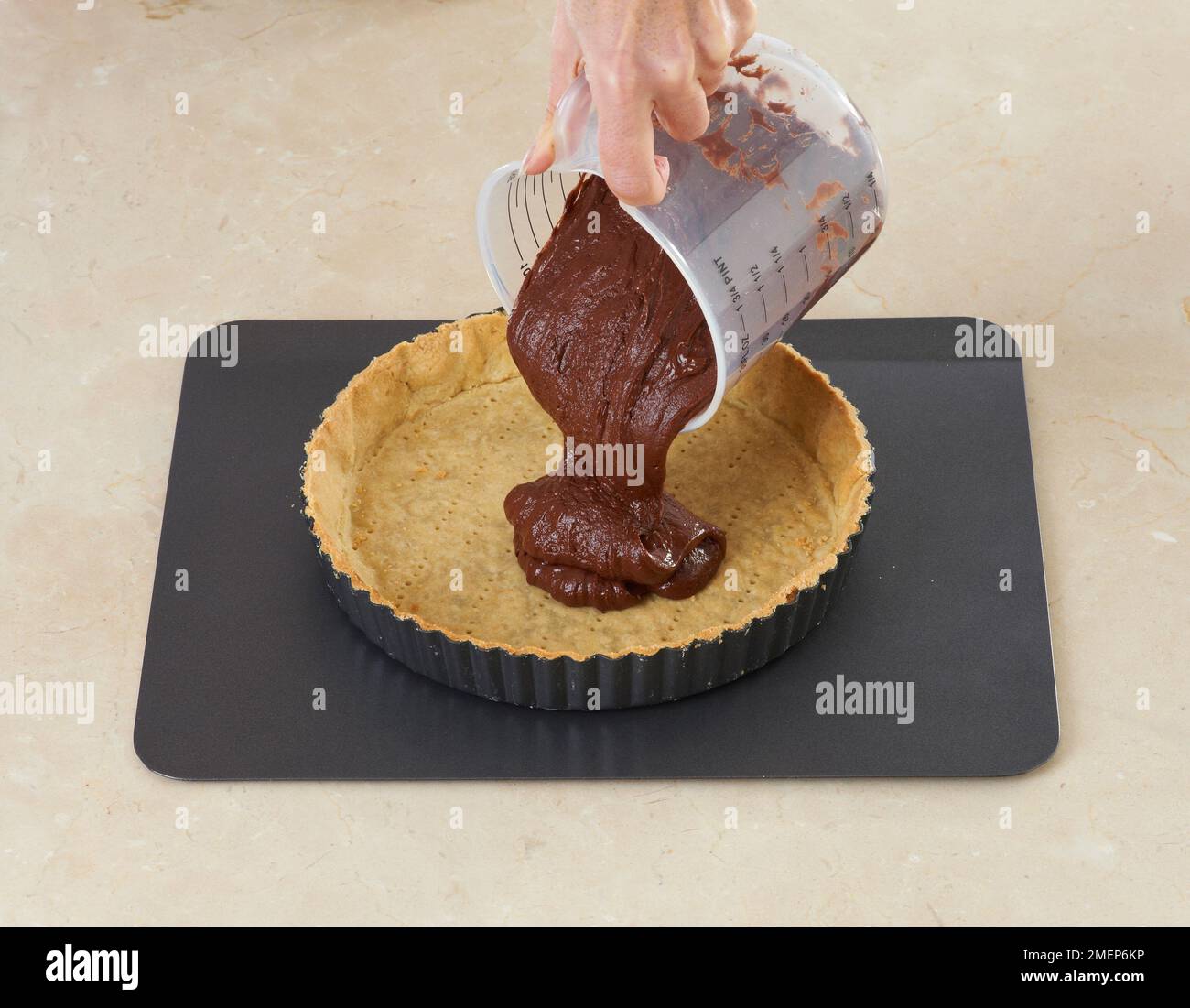 Chocolate Tart, pouring the filling into the pastry case Stock Photo