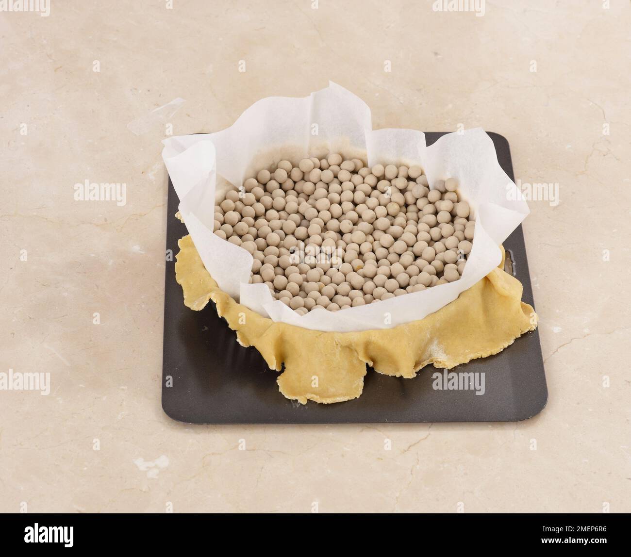 Blind baking a pastry case for a tart, using baking beans Stock Photo