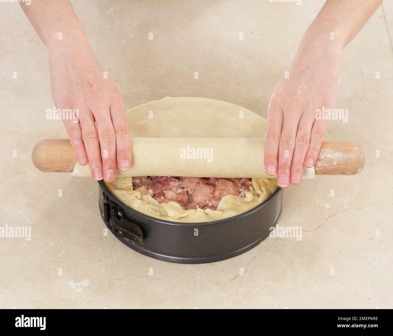 Chicken and Ham Raised Pie, covering with dough to make lid Stock Photo