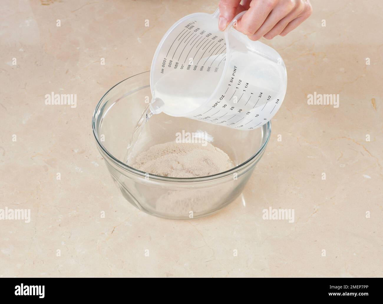Making starter for sourdough bread, dissolving yeast in lukewarm water Stock Photo