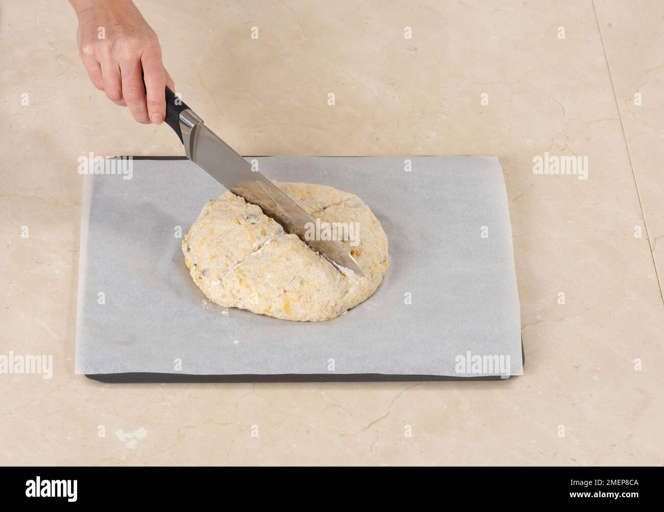 Slashing a cross into pumpkin bread dough, soda bread Stock Photo - Alamy