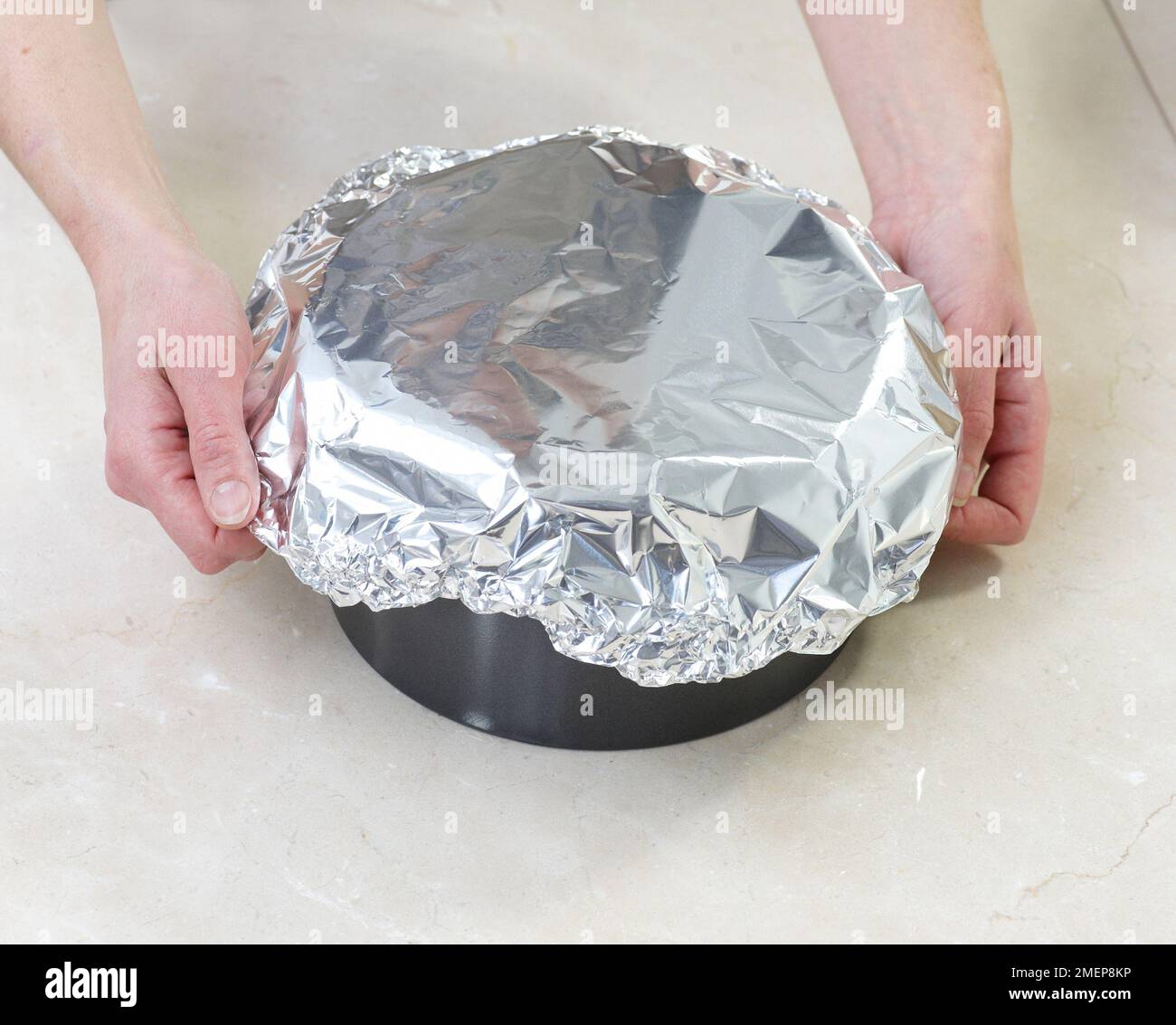 Rich Fruit Cake, covering tin with foil before baking Stock Photo
