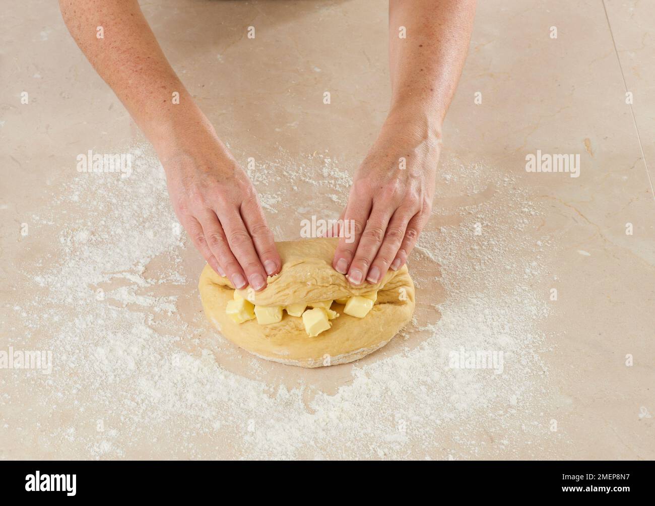 Making Brioche des rois, folding dough over butter Stock Photo Alamy