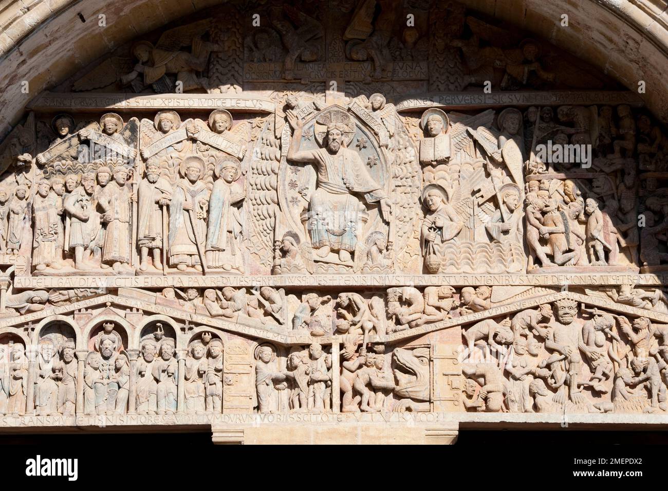 France, Midi-Pyrenees, Aveyron, Conques, Abbey Church of Saint Foy, religious relief carvings on the tympanum above entrance Stock Photo