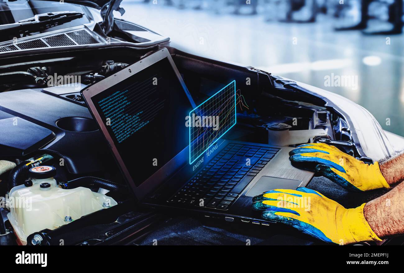 Technician is tuning engine car with a computer software of the laptop