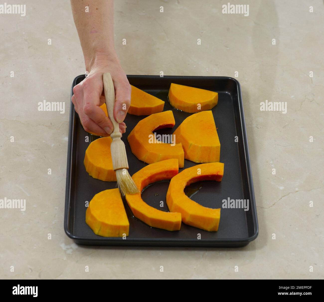 Brushing butternut squash with oil Stock Photo Alamy