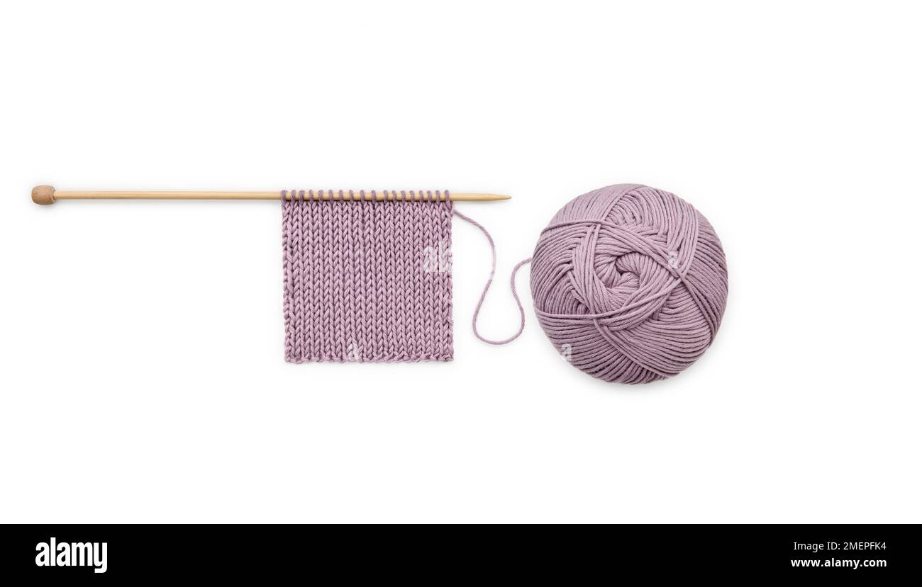 Ball of dark pink soya or milk protein yarn and knitted sample on