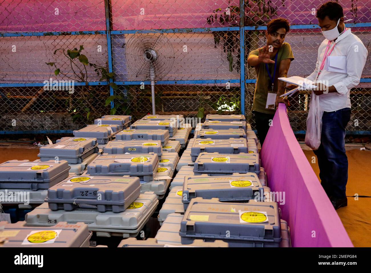 Officials check electronic voting machines at a distribution center