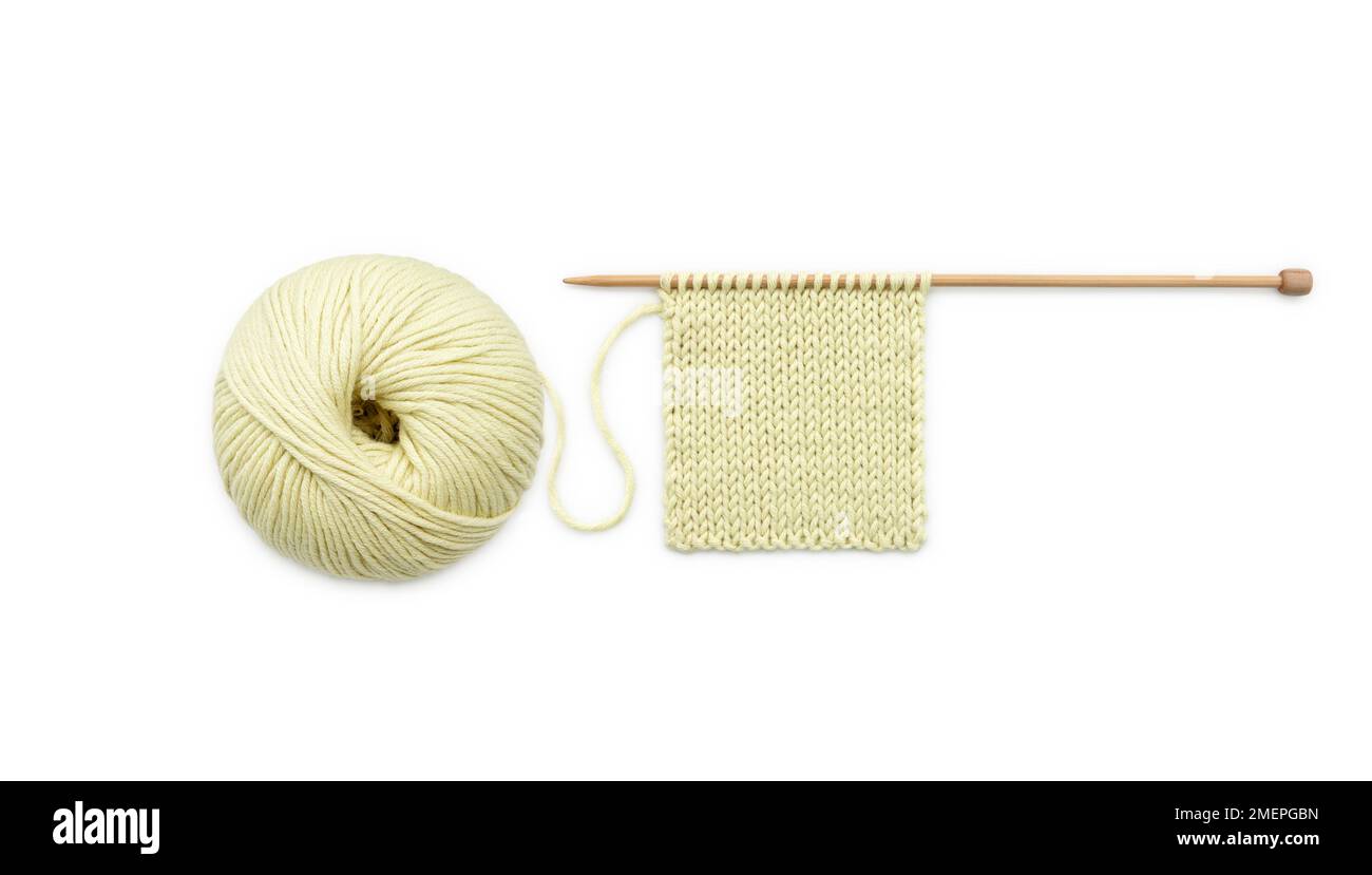 Ball of mix of wool and cotton yarn and knitted sample on knitting