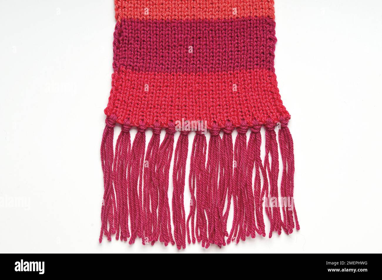Tassels on stripy red wool scarf Stock Photo
