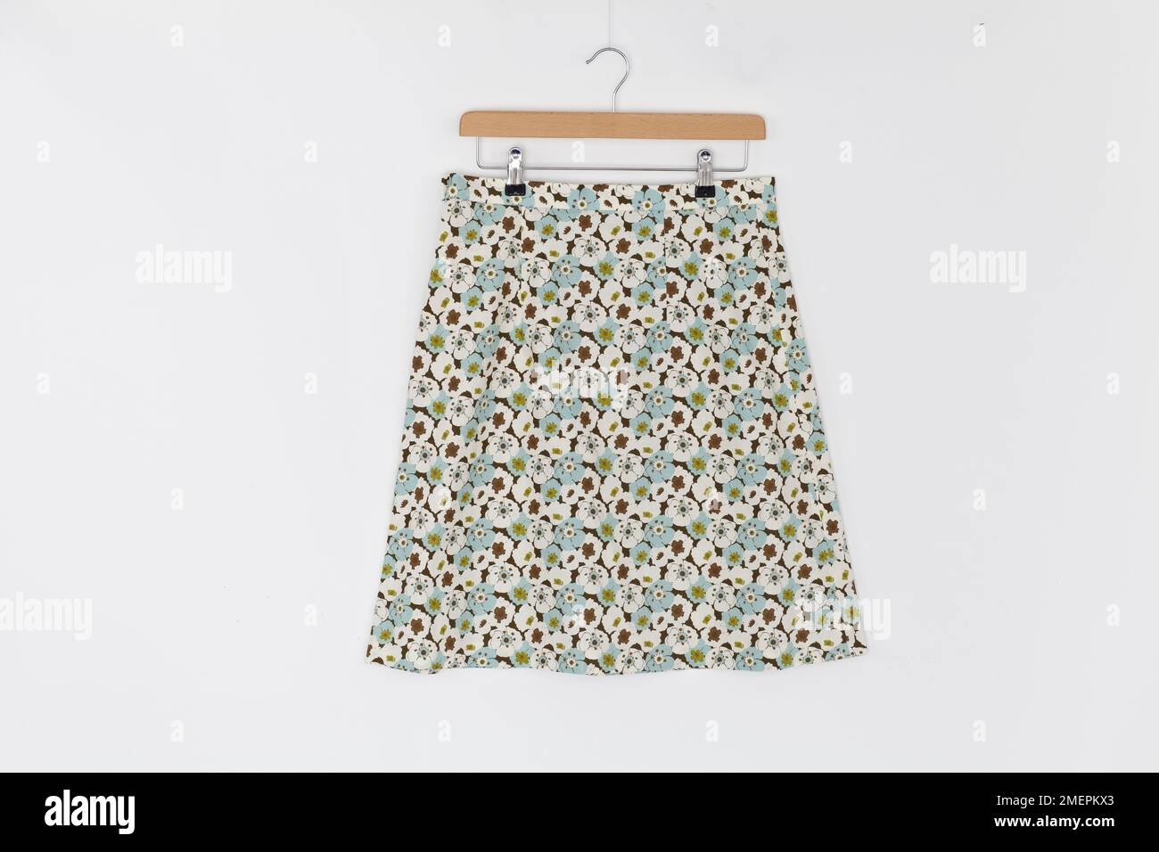 Simple a-line floral fabric skirt with narrow waistband on skirt hanger Stock Photo