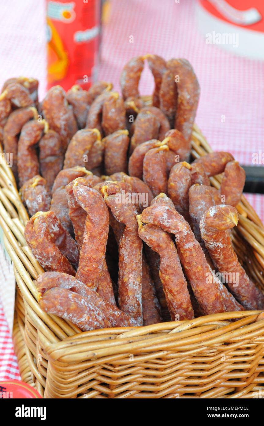 Wicker basket full of Pfefferwurst, small German Rohwurst sausages Stock Photo