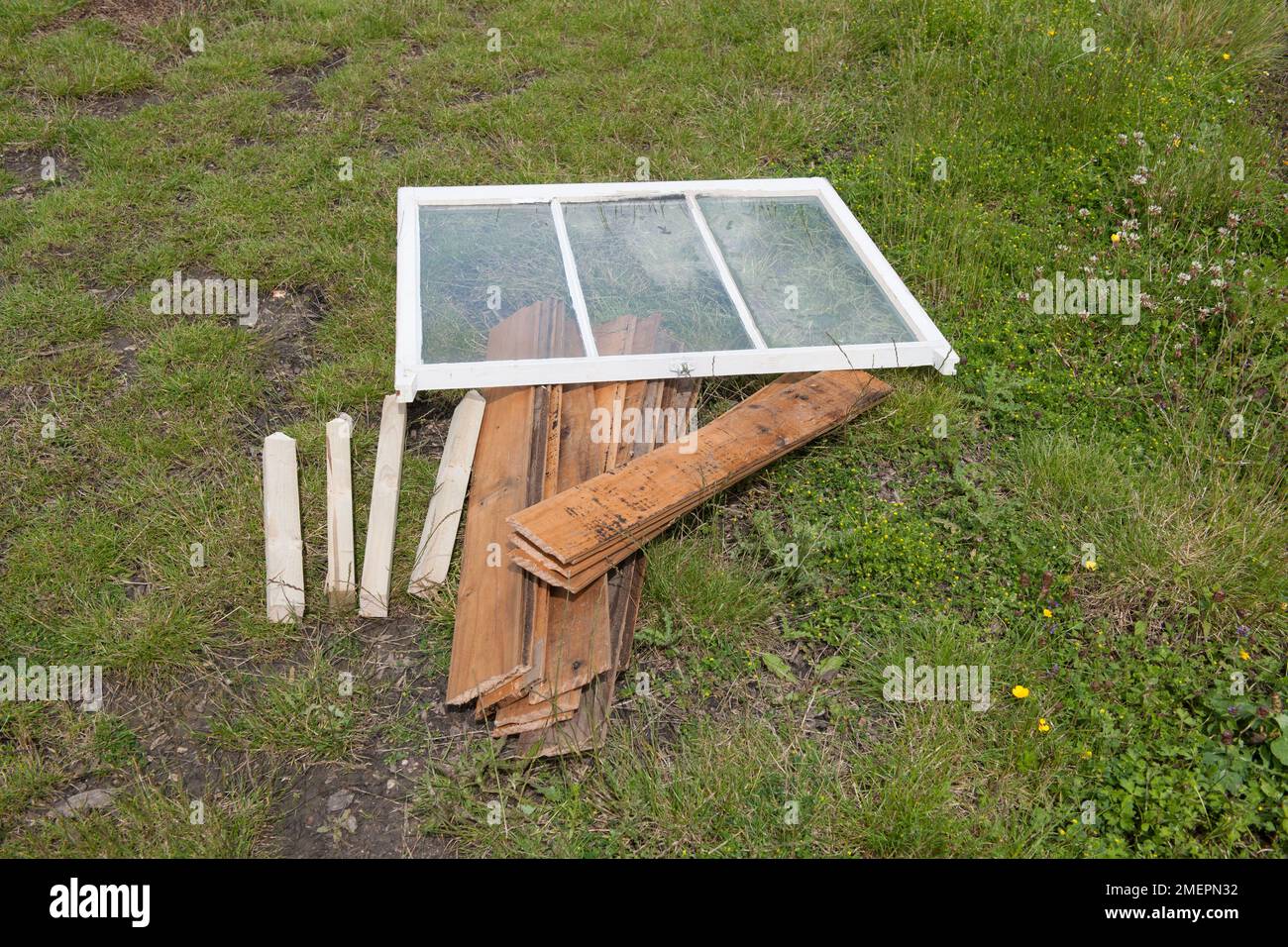 Recycled planks of wood and window, materials for constructing cold frame Stock Photo