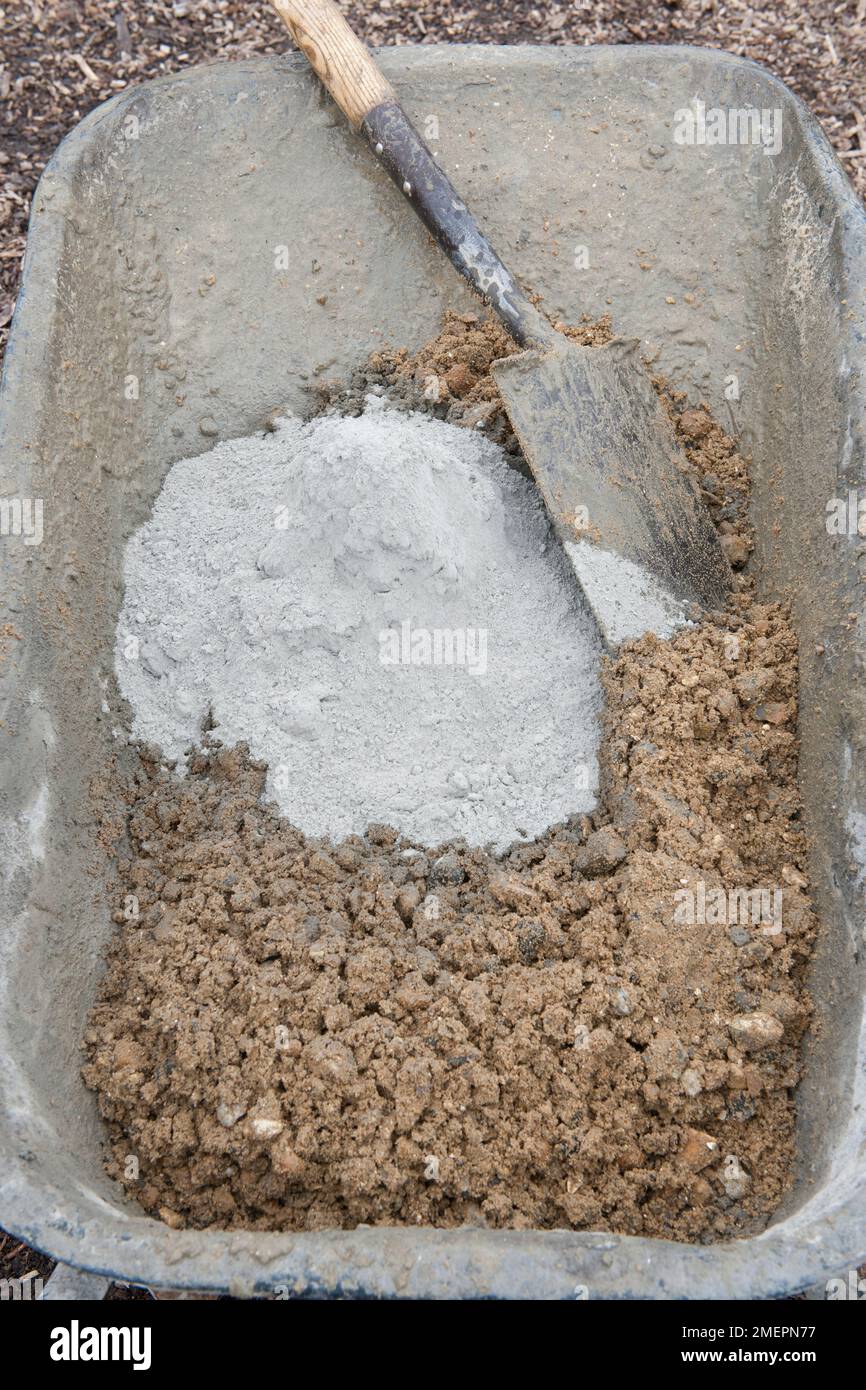 Mixing concrete with sand in wheelbarrow Stock Photo Alamy