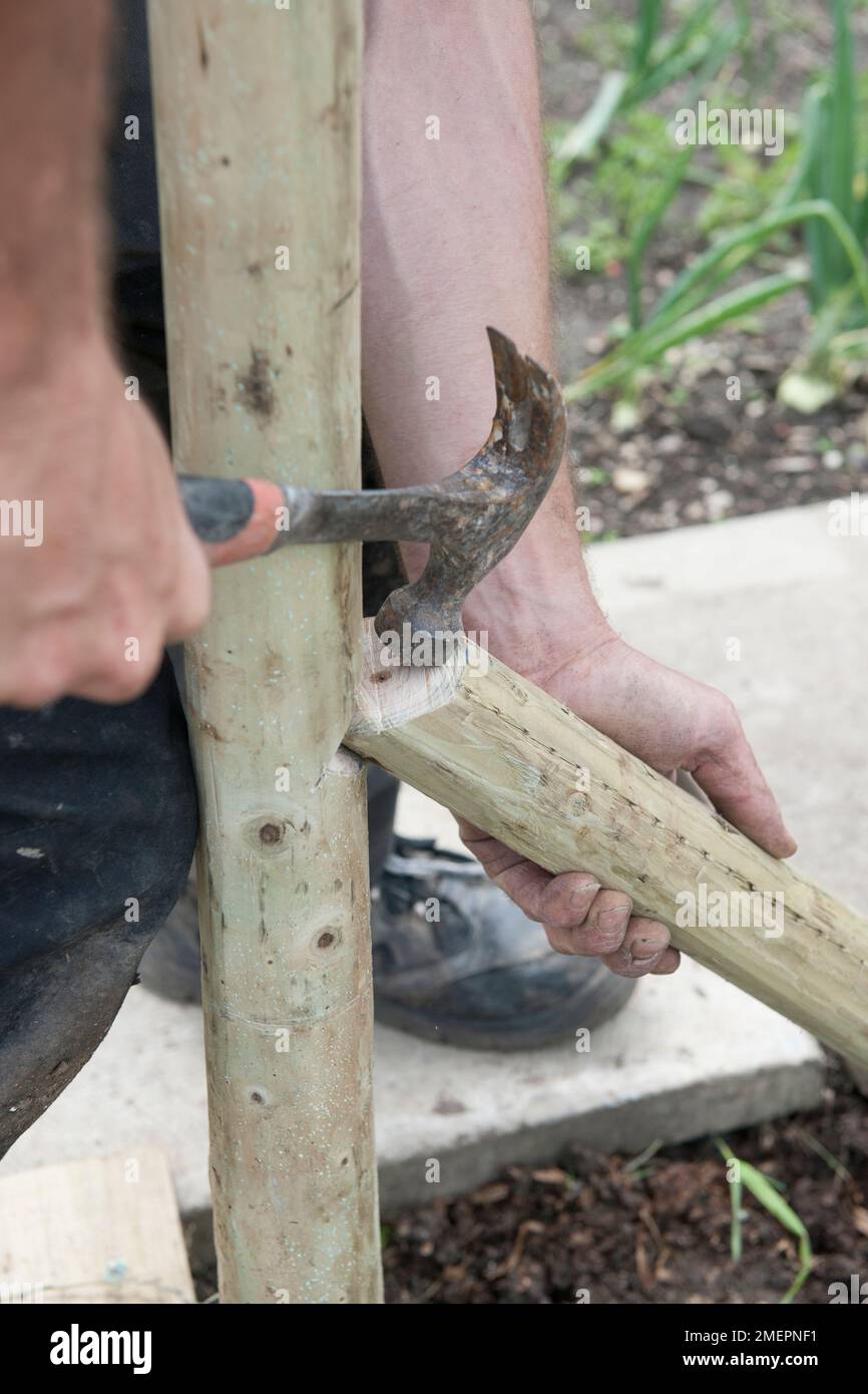 Man using hammer to fit fence post Stock Photo Alamy
