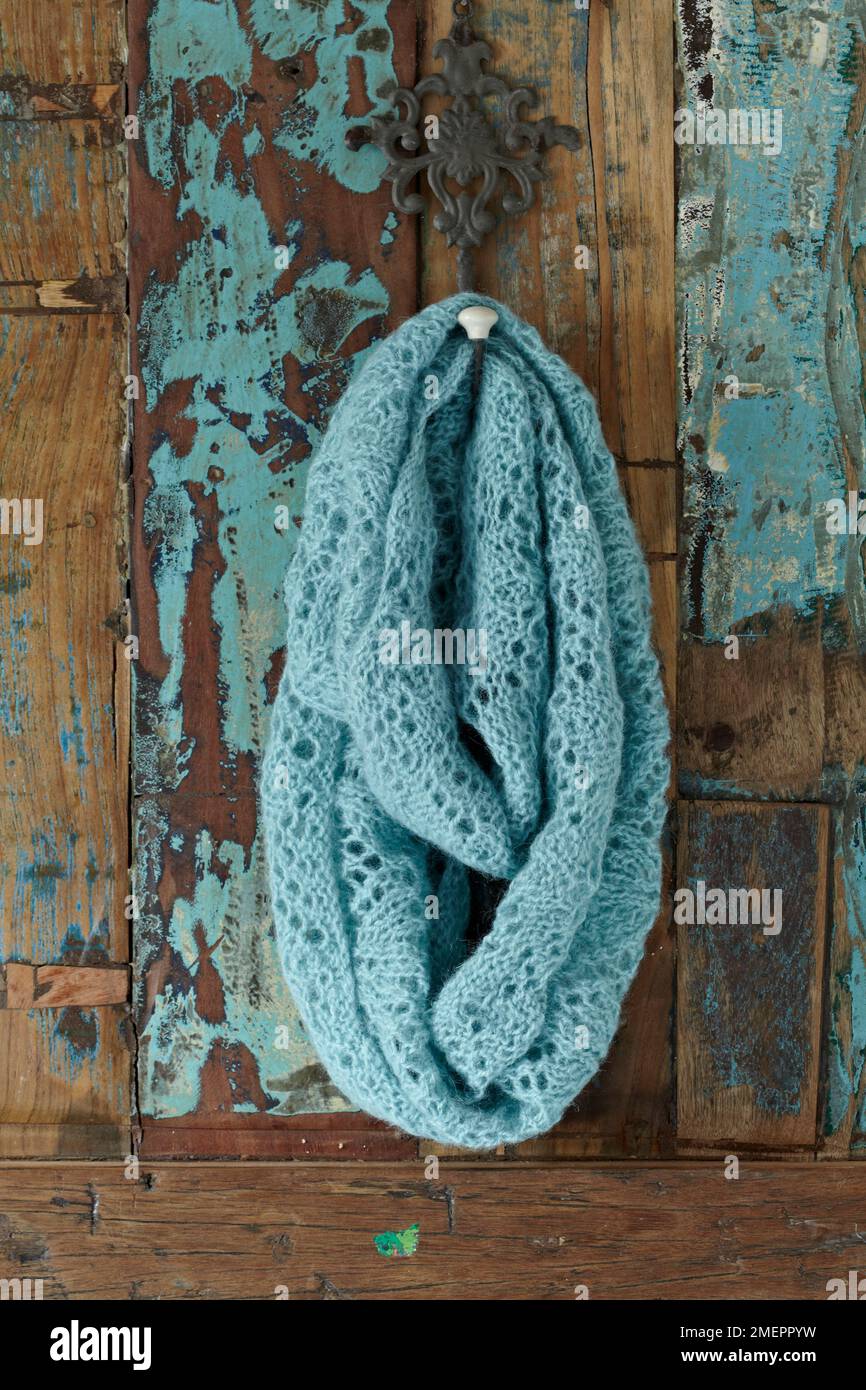 Lace-patterned, turquoise wrap against wood background Stock Photo