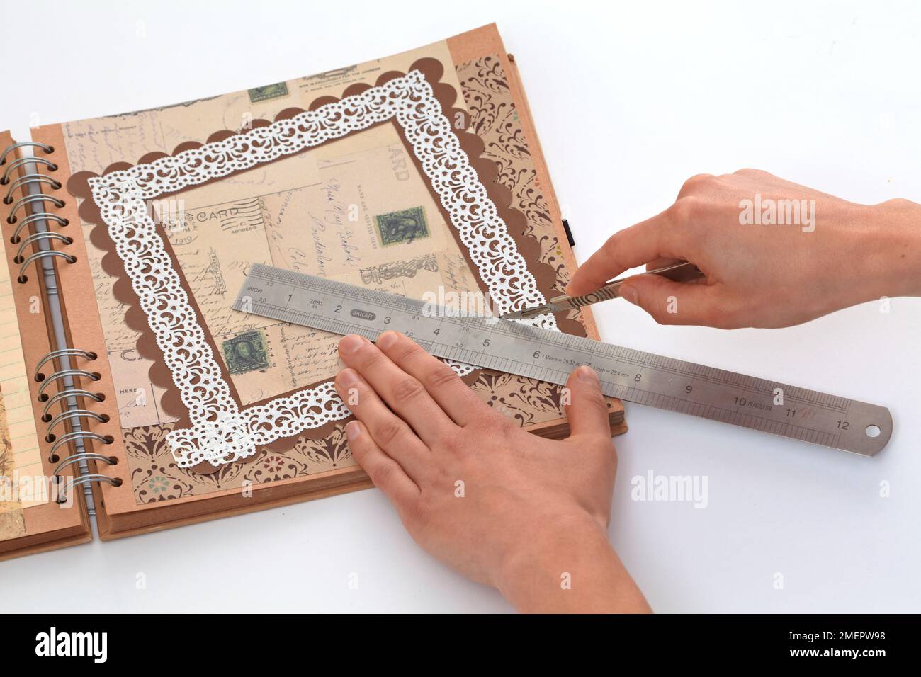 Using steel ruler and craft knife to trim decorative frame for ...