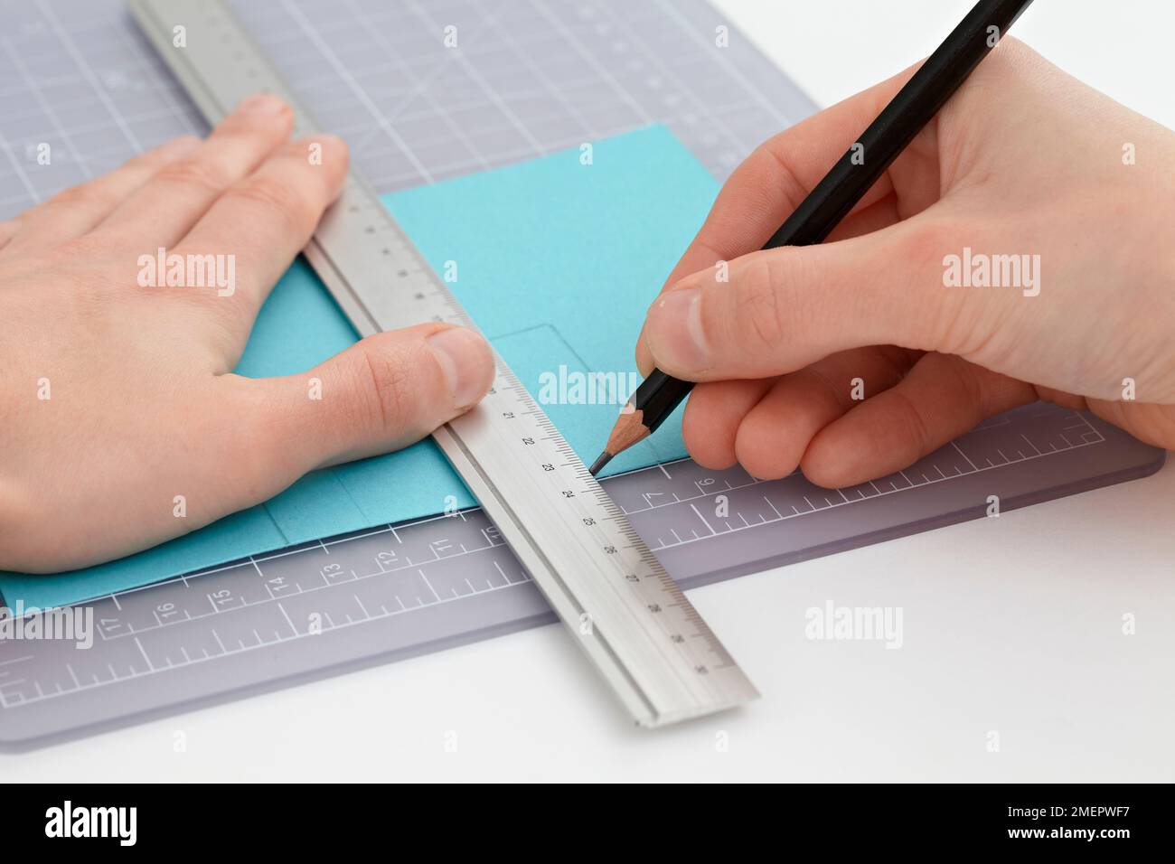 Using steel ruler and pencil to measure lines in card, closeup Stock Photo Alamy