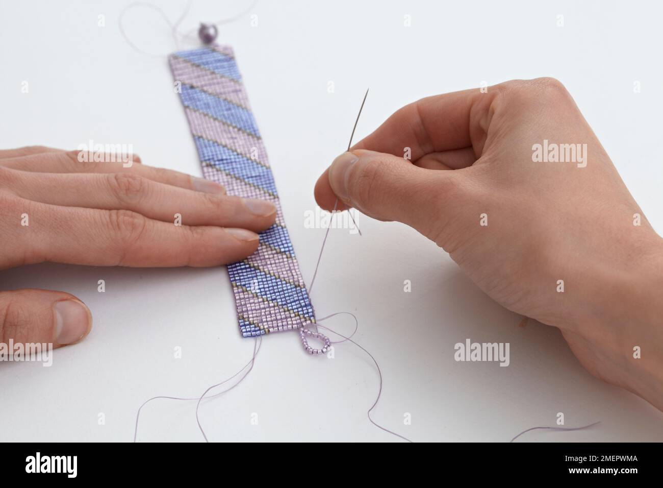 Making a loom-woven bead cuff, sewing loop, close-up Stock Photo