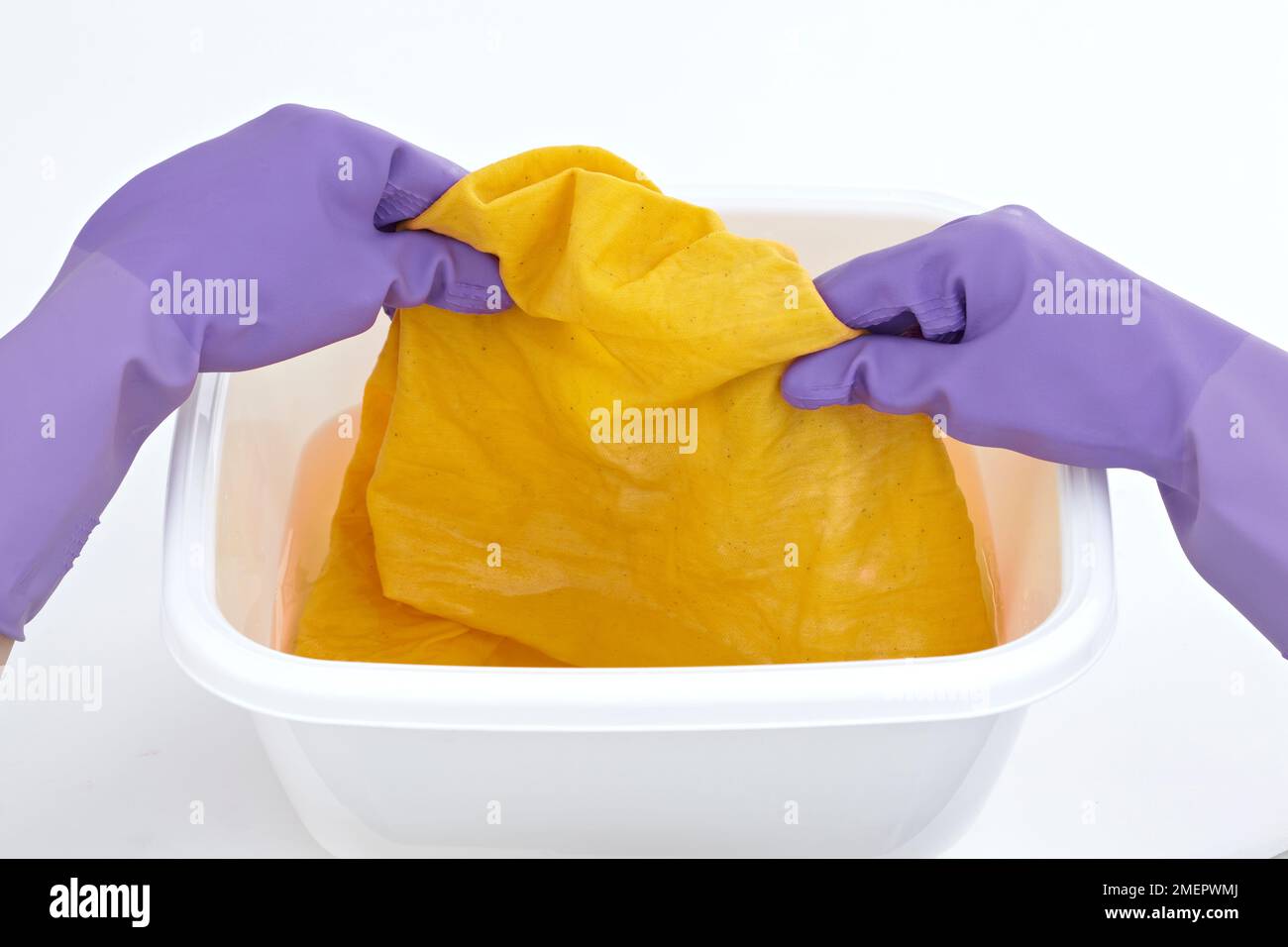 Dyeing fabric, removing item from dye bath, close-up Stock Photo