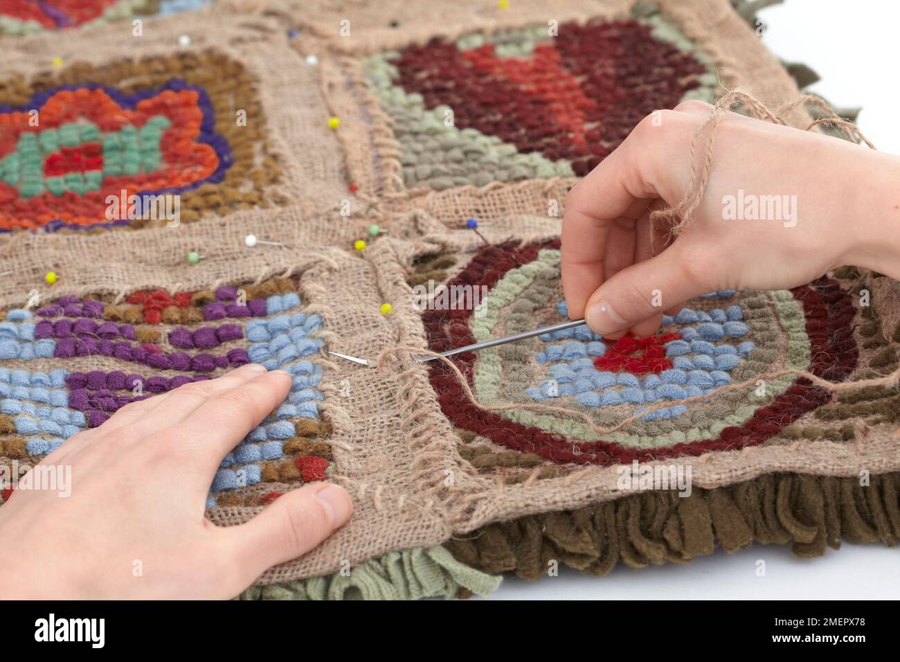 Using strong thread to sew squares together, face down, to make rag rug