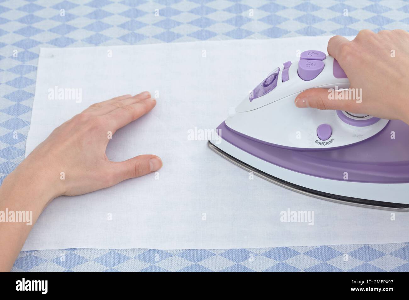 Ironing fabric to remove creases before painting, closeup Stock Photo