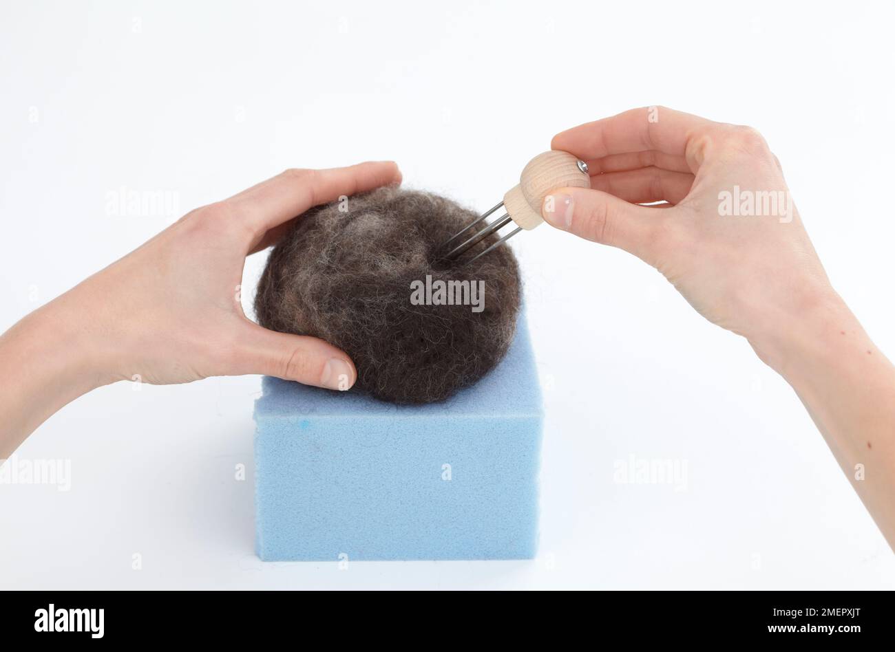 Needle felting, using multineedle tool to stab loose ball of fibres