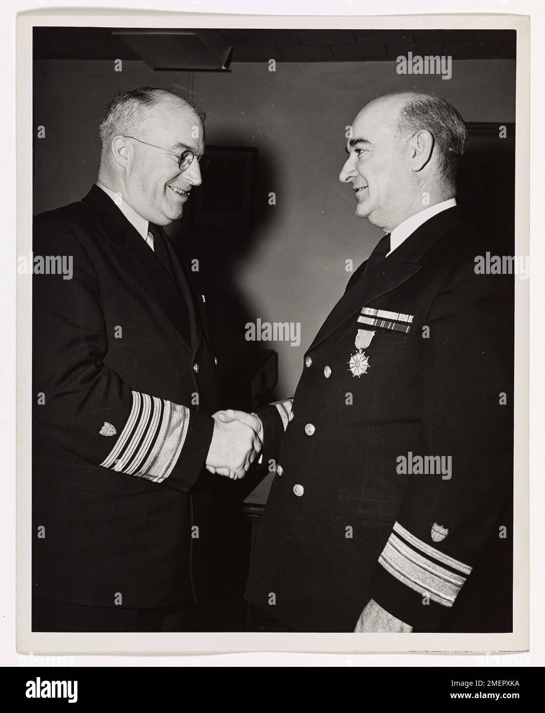 Washington Coast Guard Officer Awarded Legion of Merit. Admiral Joseph F. Farley, USCG, Coast Guard Commandant, shakes hands with Rear Admiral Frank J. Gorman, USCG, of Washington, D.C., Chief, Planning and Control Staff at Coast Guard Headquarters, after presenting him with a Legion of Merit. The medal was awarded to Rear Admiral Gorman by James Forrestal, Secretary of the Navy, in recognition of his outstanding services to the United States Government as the Coast Guard's Chief Finance and Supply Officer; and his assistance to the Commandant as special adviser on matters of organization, leg Stock Photo