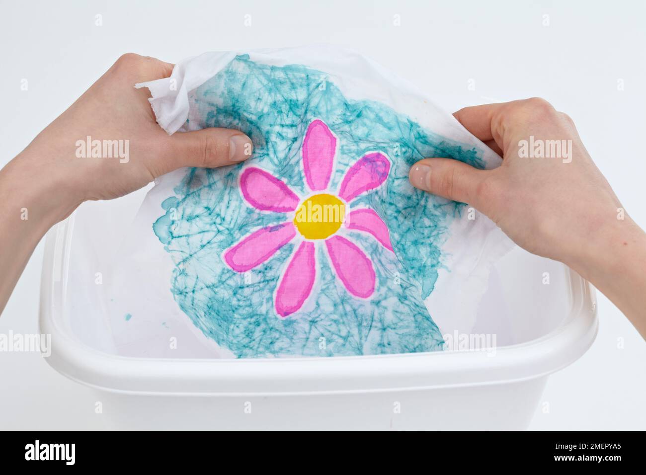 Rinsing batik fabric flower in tub of warm water, close-up Stock Photo
