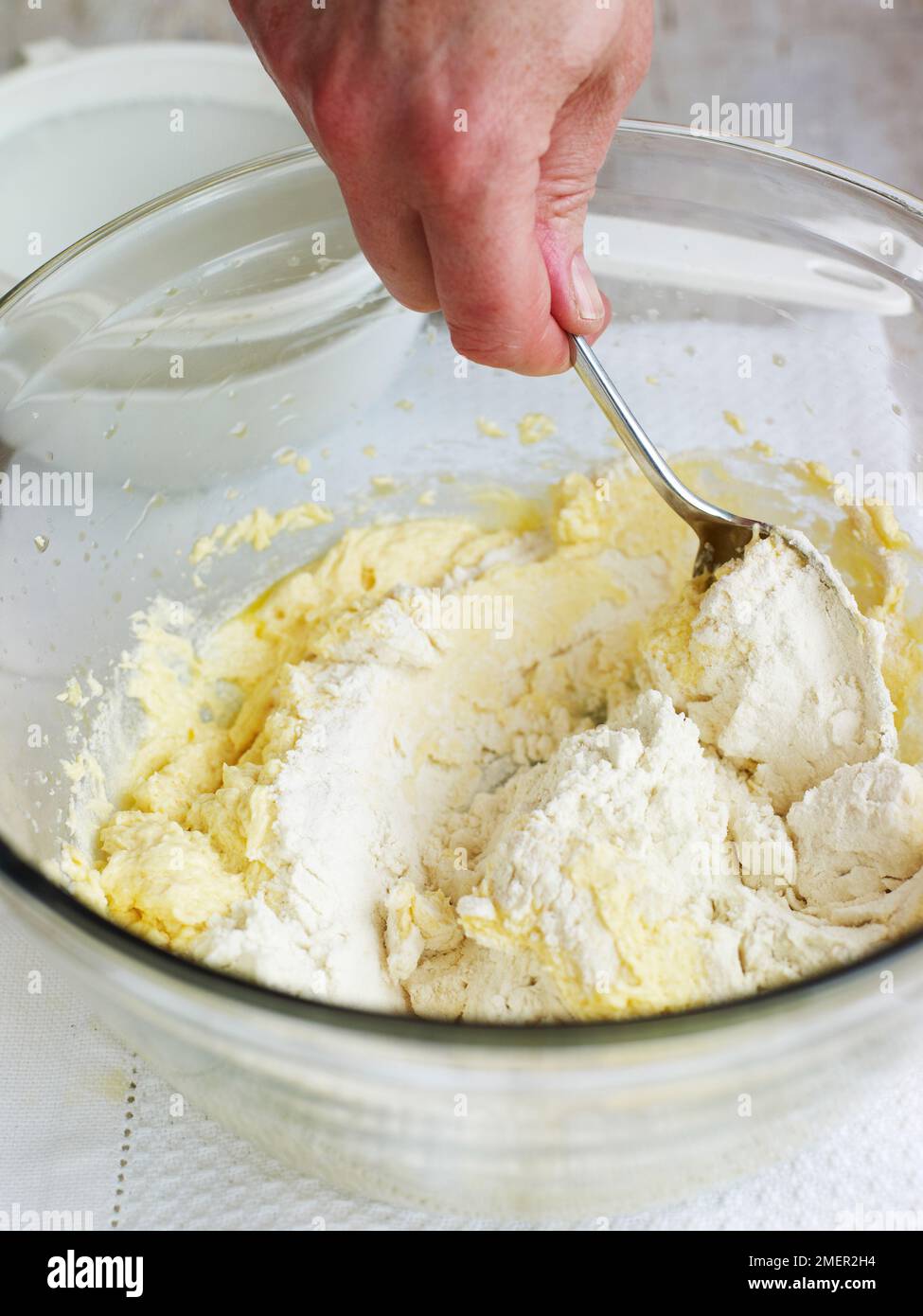 Mixing together ingredients for Victoria sponge cake, folding in flour