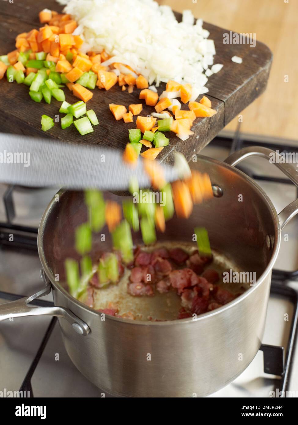 Adding ingredients to pan to make espagnole sauce Stock Photo Alamy
