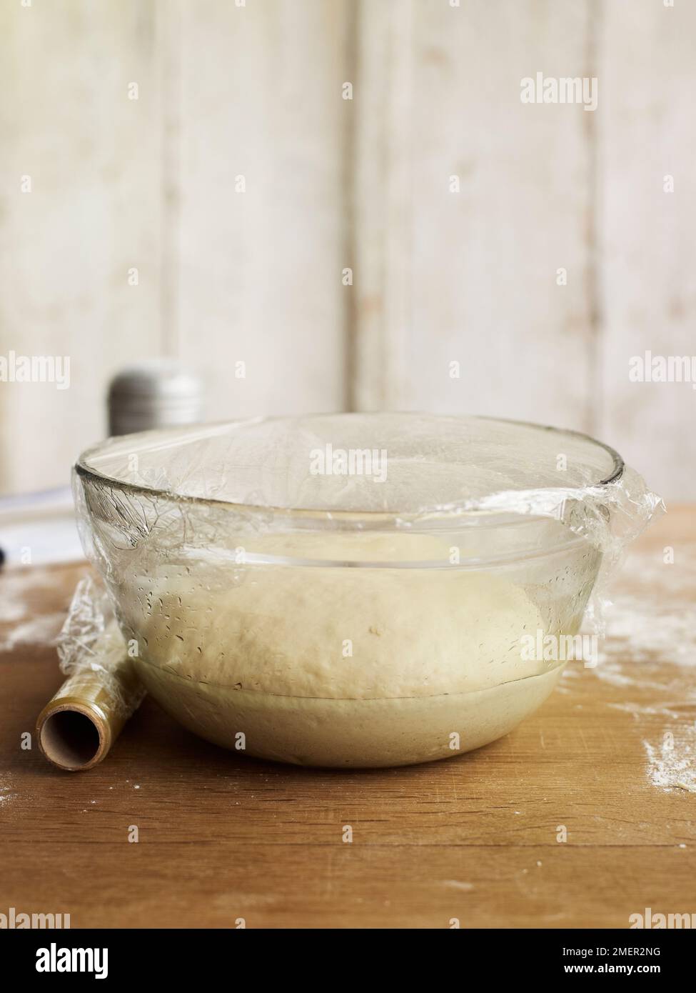 Bread dough rising in bowl, covered with clingfilm Stock Photo