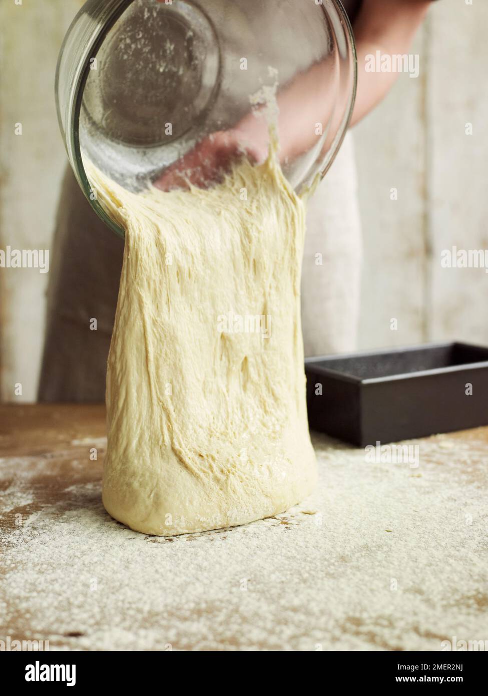 Turning out risen bread dough onto floured surface Stock Photo Alamy
