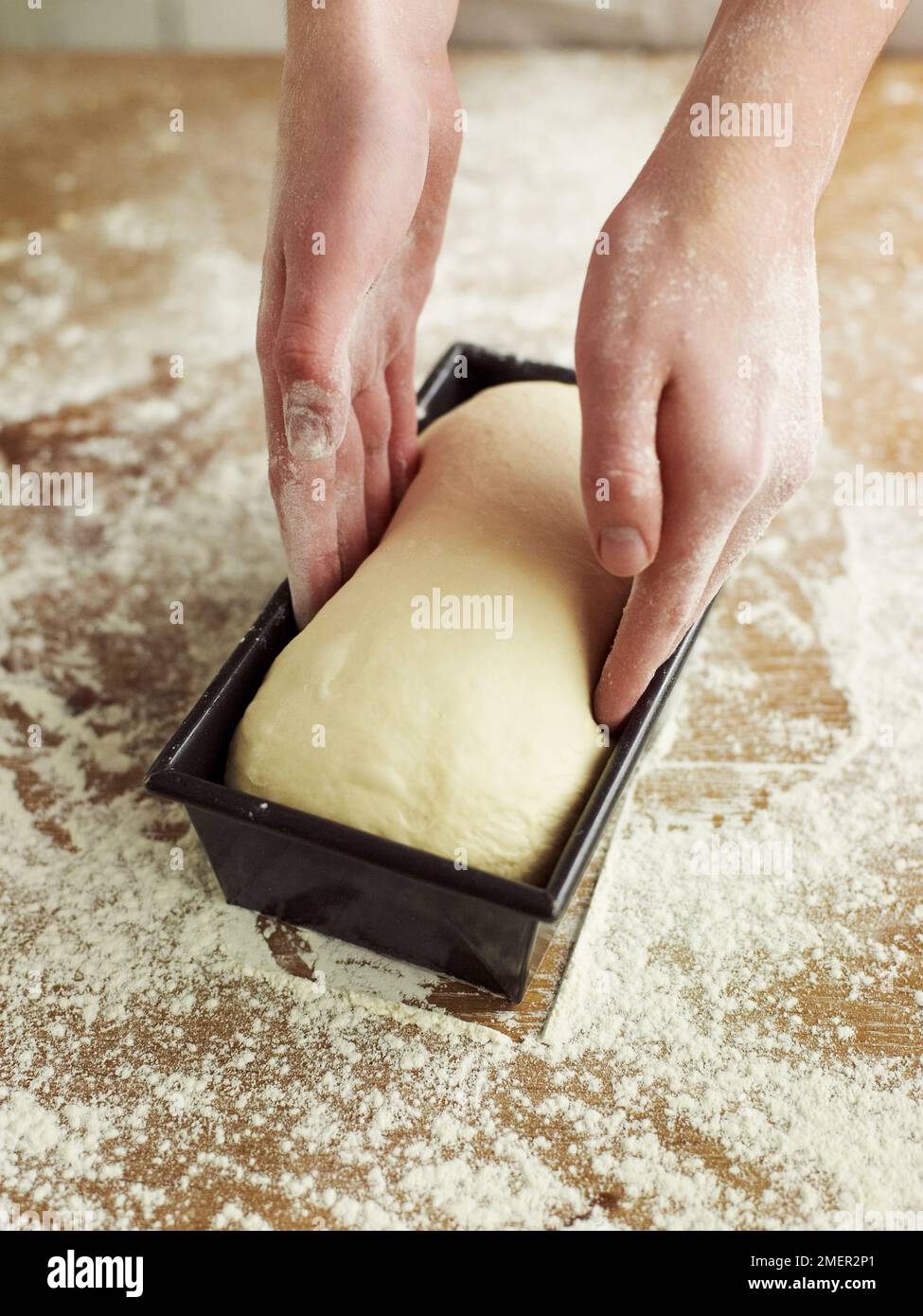 Placing partially risen bread dough in loaf tin Stock Photo Alamy